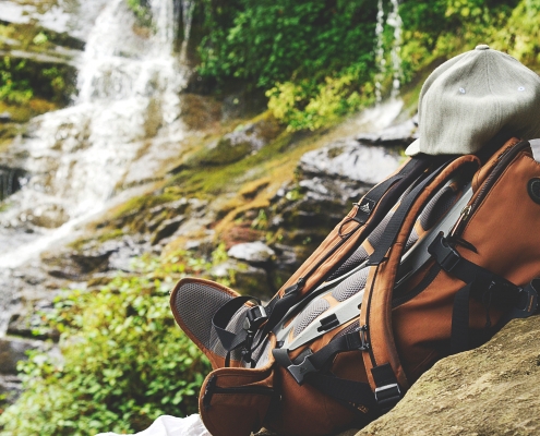 Shallow focus photography of backpack on top of boulder